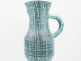 a blue vase that is sitting on a white surface