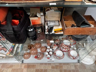 une étagère en verre sur laquelle sont posés de nombreux objets, dans une pièce