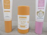 two tubes of sunscreen cream and a tube of sunscreen cream on a table