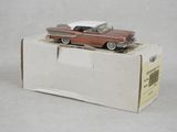 une petite voiture rouge posée sur une boîte en carton