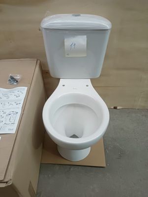 a white toilet sitting next to a cardboard box on the floor