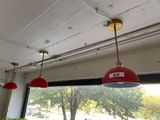 three red lamps hanging from the ceiling of a restaurant