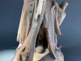 statue of a woman holding a baby in her arms on top of a wooden base