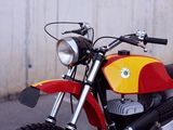 a red and yellow motorcycle parked in front of a white wall