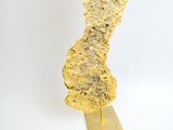 une pépite d'or posée sur un socle en or, sur fond blanc