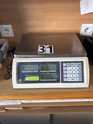 une photo d'une balance posée sur un bureau, à côté d'une calculatrice