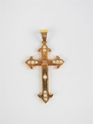 un pendentif en forme de croix en or serti de diamants sur fond blanc
