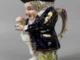a figurine of a man wearing a hat and holding a pipe