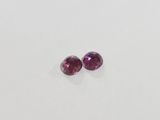 a pair of pink sapphires on a white surface