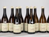 six bouteilles de vin sont alignées sur une table
