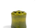 a green vase with holes in it on a white surface