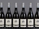 six bottles of wine are lined up in a row on a table