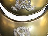 pair of antique brass collars with crest and laurels on them