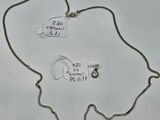 deux colliers avec des étiquettes attachées, posés sur une surface blanche