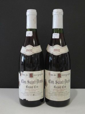 two bottles of wine sitting on top of a table next to each other