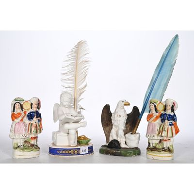 three figurines of people and a bird with a feather on a table