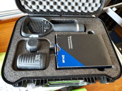une mallette rigide contenant une radio et un micro, posée sur une table