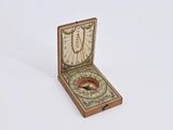 une petite boîte en bois avec une boussole à l'intérieur
