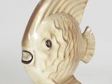 a ceramic fish figurine sitting on a white surface