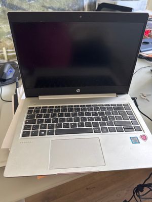 un ordinateur portable ouvert posé sur un bureau, à côté d'un écran d'ordinateur