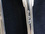 two spoons and a fork on a black cloth