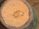 a close up of a green vase with a brown lid