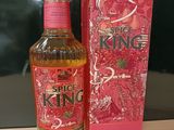 La bouteille de « Spice King » se trouve à côté de la boîte, sur la table.