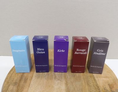 four boxes of blue, purple, and black perfume sitting on a wooden board