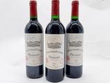 trois bouteilles de vin rouge posées l'une à côté de l'autre sur une surface blanche