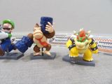 three figurines of nintendo characters on display on a table