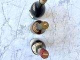 three bottles of wine sitting on a marble table
