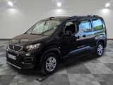 La camionnette noire est garée sur un sol en damier dans un garage.