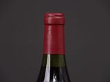 a bottle of red wine with a red cap on a black background