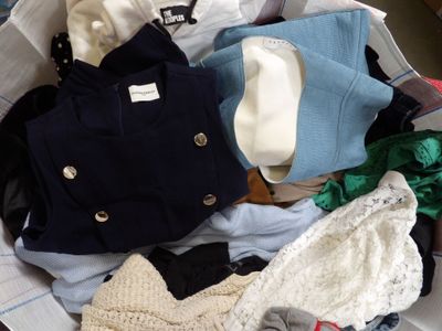 a suitcase full of clothes and a hat on the bed