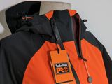 an orange and black jacket with an orange tag on it