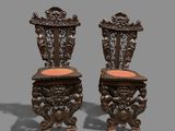 pair of antique carved wood chairs with orange upholstered cushions
