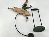 a figurine of a man riding a pig on a wire
