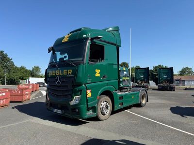 un camion vert garé sur un parking