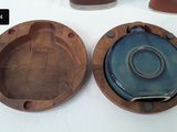 three wooden plates and a bowl sitting on a table