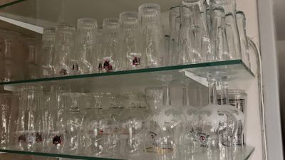 une étagère en verre sur laquelle sont posés de nombreux verres