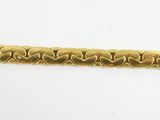 a close up of a gold bracelet on a white surface