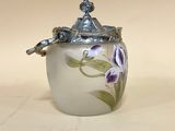 un vase blanc orné de fleurs violettes, posé sur une table