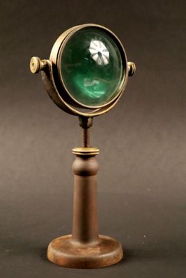 a close up of a green light on top of a wooden stand