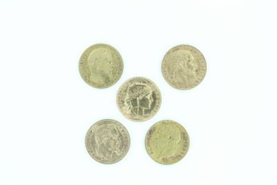 Quatre pièces de monnaie britanniques sont disposées en cercle sur une surface blanche.