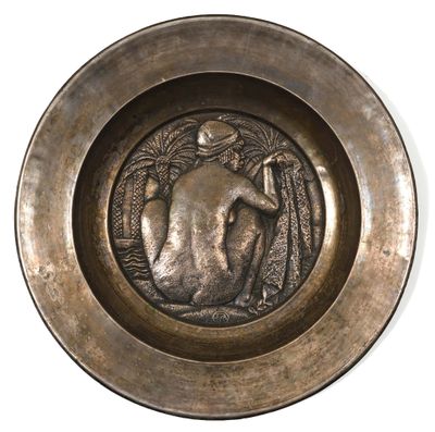 une plaque en bronze sur laquelle figure, au centre, l'image d'une femme