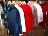 a lot of clothes hanging on a rack in a room
