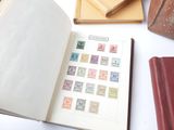 a book with stamps on it sitting on a table next to other books