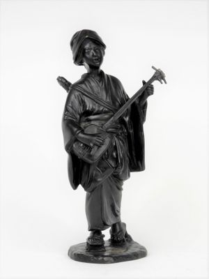 photographie en noir et blanc représentant la statue d'un homme tenant une guitare