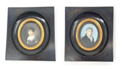 deux portraits encadrés représentant un homme et une femme, dans des cadres noirs et dorés