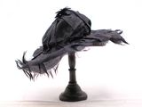un chapeau noir posé sur un support noir, sur fond blanc